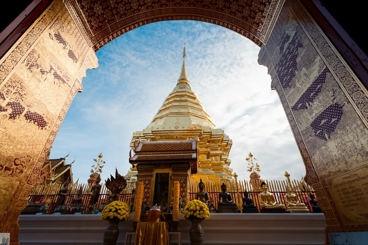 Golden chedi at Doi Suthep in Chiang Mai framed by an ornate temple arch