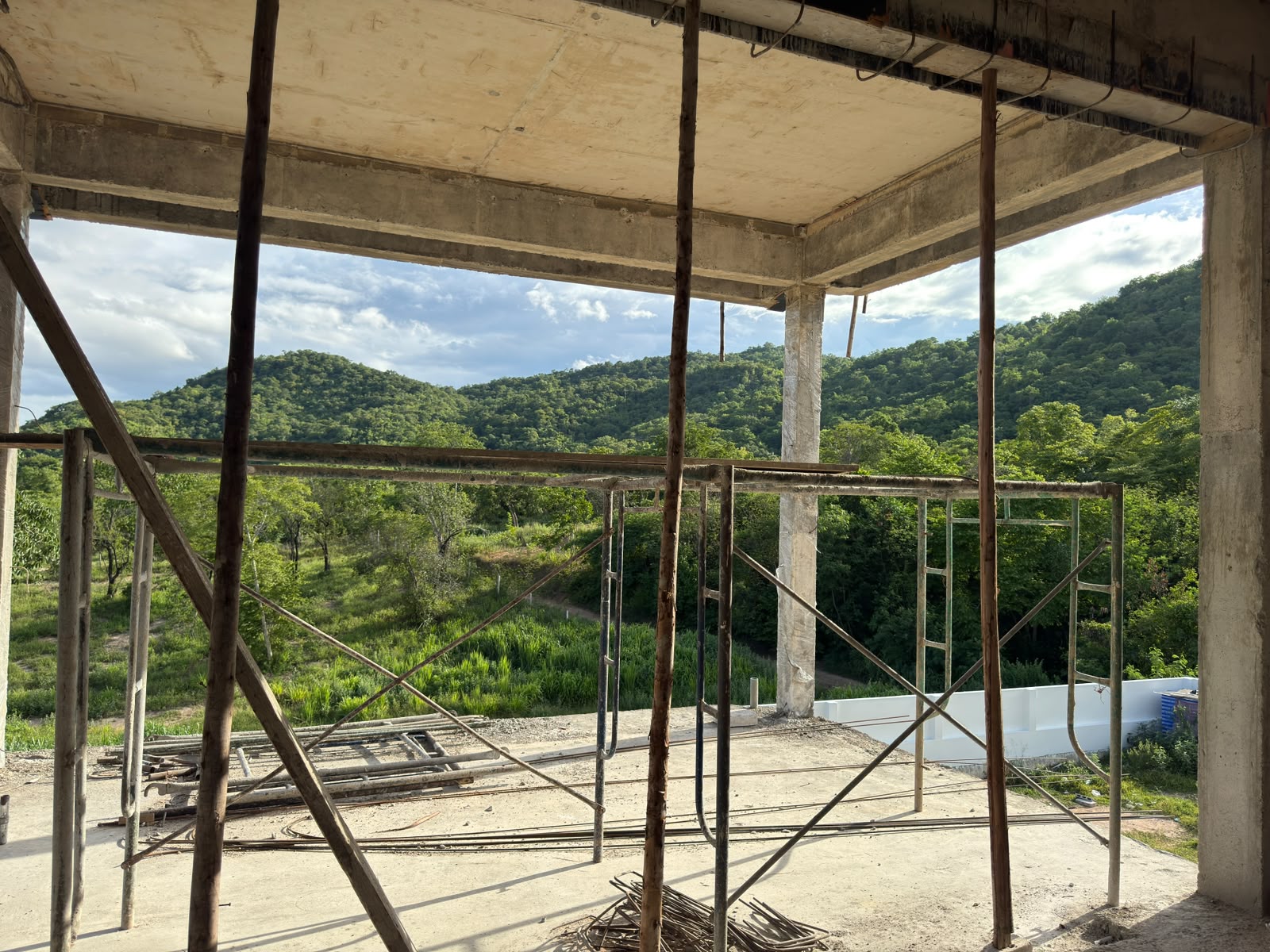 Wide hillside view framed by the reinforced concrete structure of a villa under construction at The Vista Hua Hin.