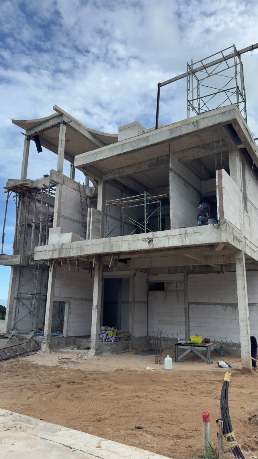 Two-storey Type C villa under construction at The Vista Hua Hin, showing reinforced concrete structure, curved roof form and blockwork walls.